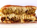 Una fetta di tiramisù, con strati di savoiardi inzuppati e crema al mascarpone, spolverata di cacao. La ricetta perfetta per un dolce indimenticabile.