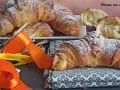 Croissant dorati e soffici, dolci lievitati spolverati di zucchero a velo, pronti per una colazione speciale.