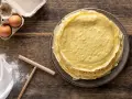 Pila di crepes dorate, pronte per essere farcite. Accanto, uova fresche e farina, ingredienti perfetti per crepes 2 uova.