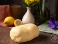 Impasto di pasta frolla che non si rompe, pronto per creare dolci perfetti. Accanto, limoni freschi e un tocco di colore.