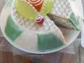 Una fetta di cassata siciliana palermitana, con decorazioni in glassa bianca e canditi colorati, mostra il suo ripieno cremoso.