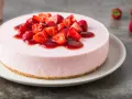 Deliziosa torta fragole e mascarpone senza cottura, guarnita con fragole fresche e salsa rossa.