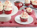 Deliziosi muffin red velvet con glassa bianca e cuoricini rossi, perfetti per San Valentino.