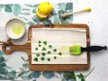 Preparazione per un piatto con pasta fillo: ingredienti come limone, miele, prezzemolo e olio su un tagliere.