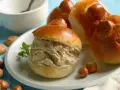 Brioches col tuppo, soffici e dorate, ripiene di gelato cremoso. Un dolce siciliano da gustare con nocciole e menta.
