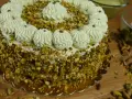 Delizioso dolce con crema al pistacchio già pronta, ricoperto di granella di pistacchi e decorato con ciuffi di crema.