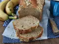 Fetta di banana bread senza burro, soffice e profumato, con croccante copertura di frutta secca. Perfetto per la colazione.