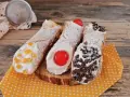 Cannoli siciliani decorati con canditi, ciliegie e gocce di cioccolato, pronti per essere gustati. Ingredienti cannolo siciliano perfetti.