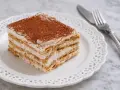 Fetta di torta stratificata con crema e cacao, perfetta per ricette con biscotti avanzati.