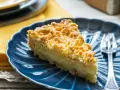 Fetta di sbrisolona con crema pasticcera su piatto blu, con forchetta trasparente.