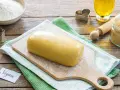 Impasto giallo pronto per biscotti, con un'etichetta "Vegan" e ingredienti come farina, zucchero e olio.