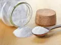 Bicarbonato in un barattolo rovesciato e un cucchiaio: ecco a cosa serve il bicarbonato nei dolci per renderli soffici e lievitati.