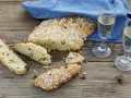 Fette di ciambella romagnola, cosparse di zuccherini, accanto a due bicchieri di spumante.