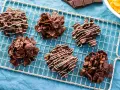 Dolcetti croccanti al cioccolato, simili a rose del deserto ricetta, su una griglia di raffreddamento. Alcuni sono decorati con cioccolato bianco.