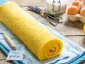 Rotolo giallo soffice, un delizioso pasta biscotto senza glutine, pronto per essere gustato. Ingredienti freschi sullo sfondo.