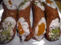 Cannoli siciliani con ripieno cremoso, gocce di cioccolato e pistacchi. Una ricetta semplice per un dolce irresistibile.