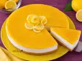 Cheesecake al limone con decorazione di fettine e rosa di limone. Una fetta è già servita.