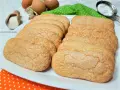 Savoiardi fatti in casa dorati e friabili, pronti per il tiramisù. Ingredienti freschi sullo sfondo.