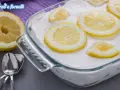 Un delizioso tiramisù al limone, guarnito con fette di limone fresco, pronto per essere gustato.
