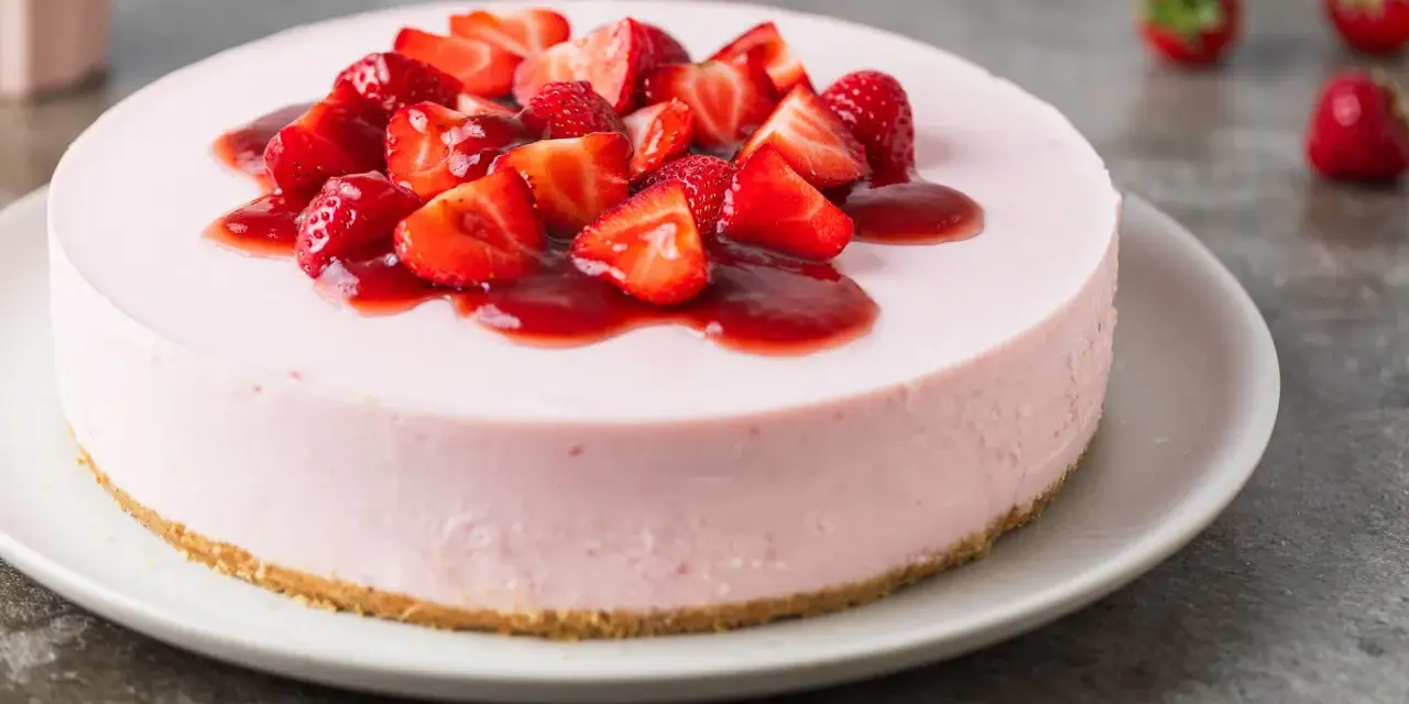 Deliziosa torta fragole e mascarpone senza cottura, guarnita con fragole fresche e salsa rossa.