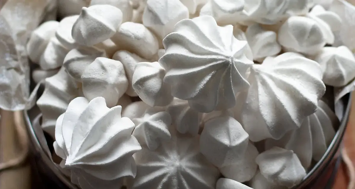 Un cesto pieno di meringhe soffici, perfette per la tua ricetta. Dolci e leggere, un piacere da gustare.