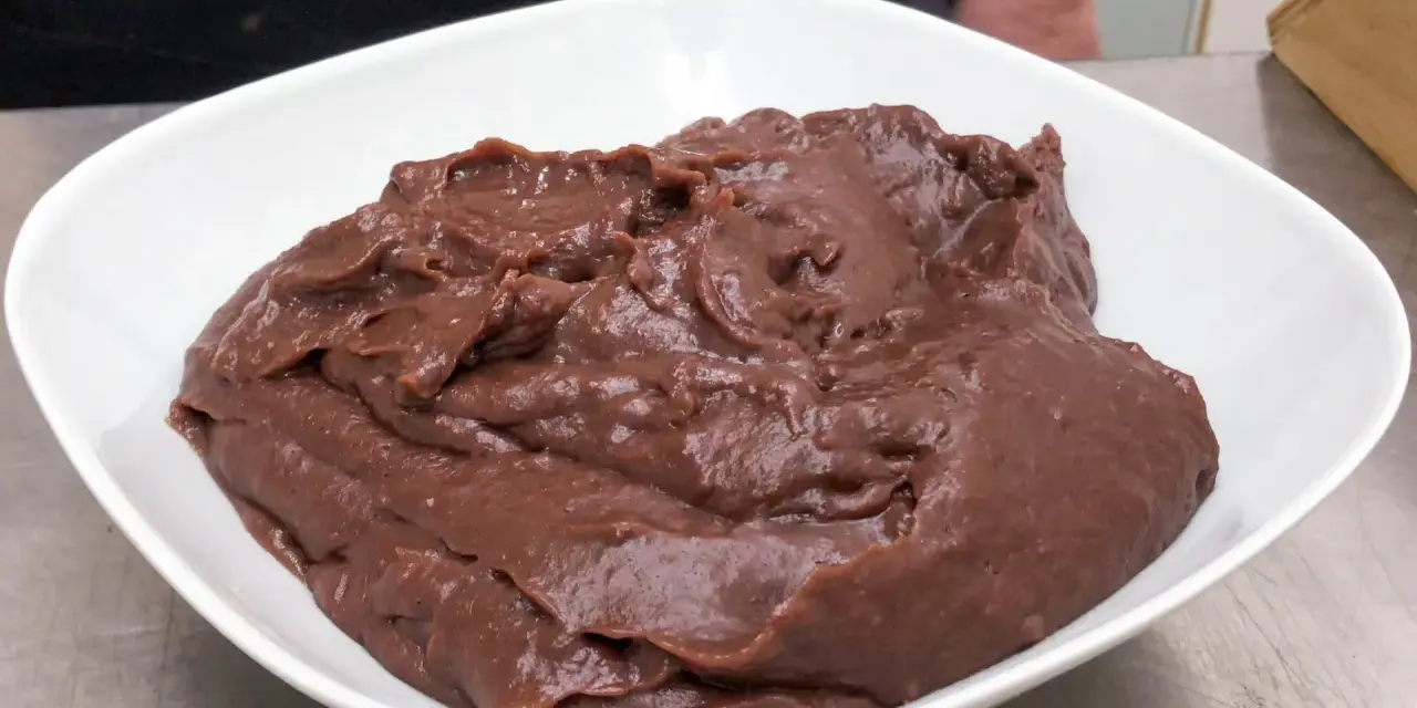 Crema pasticcera al cioccolato, densa e lucida, in una ciotola bianca.