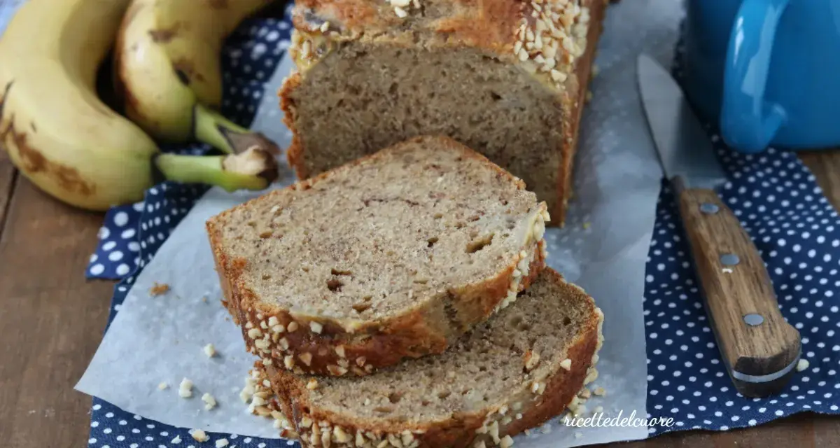 Fetta di banana bread senza burro, soffice e profumato, con croccante copertura di frutta secca. Perfetto per la colazione.