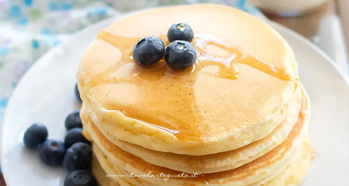 Pancakes soffici con albumi, guarniti con mirtilli freschi e sciroppo d'acero. Un dolce inizio di giornata.