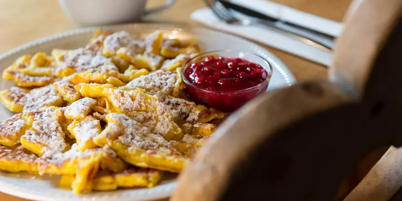 Frittata dolce tirolese cosparsa di zucchero a velo, servita con marmellata di mirtilli rossi.