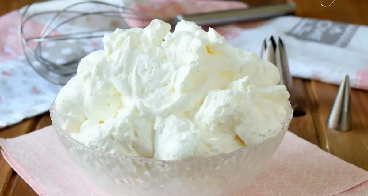 Montare la panna è facile con le fruste giuste. Ecco una ciotola piena di panna montata soffice, pronta per decorare dolci.