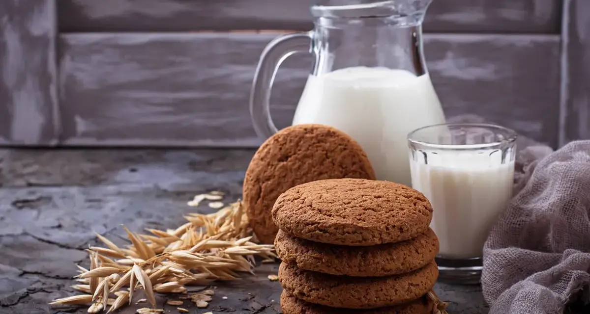 Biscotti farina di avena friabilissimi, perfetti con un bicchiere di latte fresco. Un'immagine che evoca colazioni genuine e momenti di puro piacere.