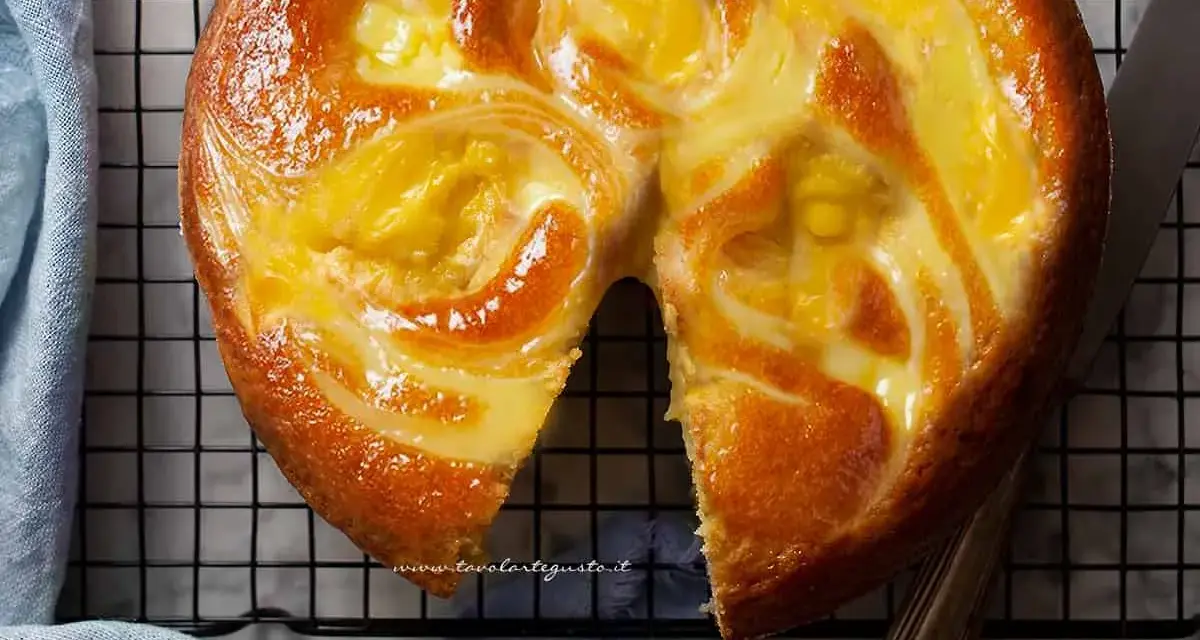 Torta soffice con un vortice di crema pasticcera dorata, appena sfornata e pronta per essere gustata.