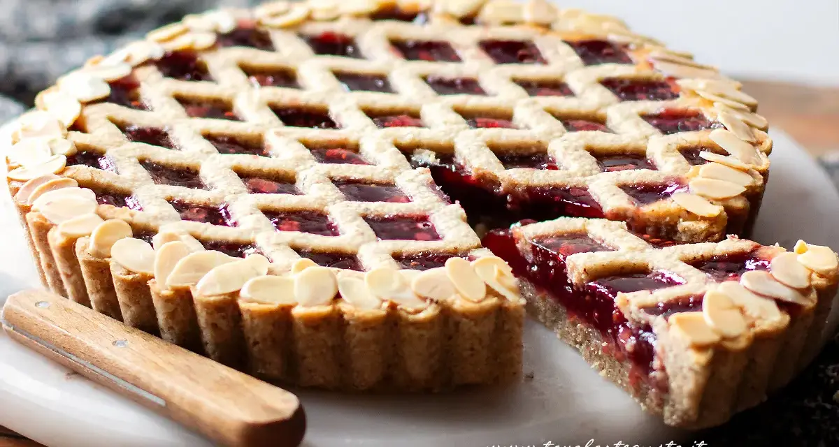 Torta Linzer ricetta originale: crostata con marmellata di lamponi e mandorle a lamelle, un classico della pasticceria.