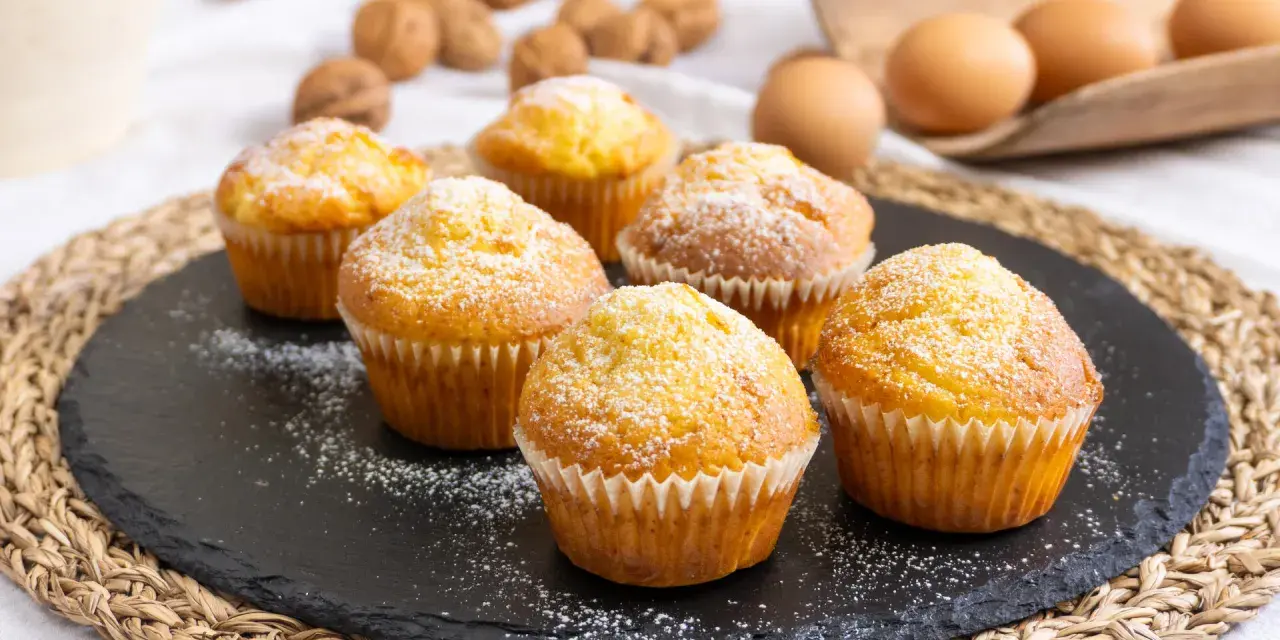 Sei muffin allo yogurt spolverati di zucchero a velo, pronti per essere gustati.