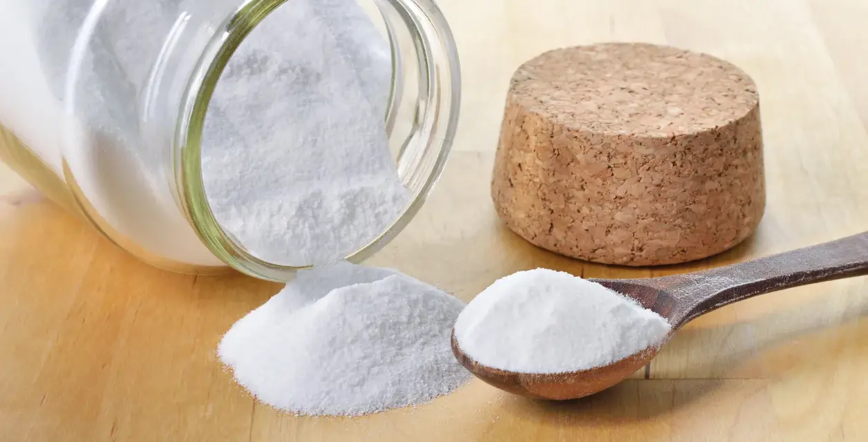 Bicarbonato in un barattolo rovesciato e un cucchiaio: ecco a cosa serve il bicarbonato nei dolci per renderli soffici e lievitati.