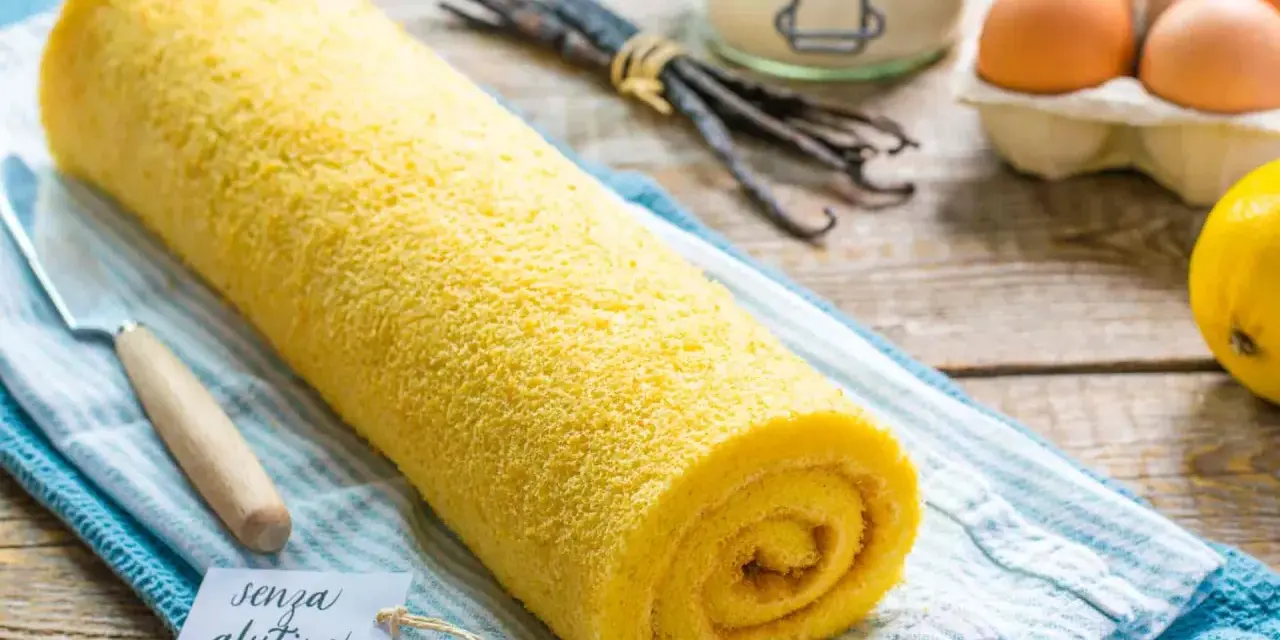 Rotolo giallo soffice, un delizioso pasta biscotto senza glutine, pronto per essere gustato. Ingredienti freschi sullo sfondo.