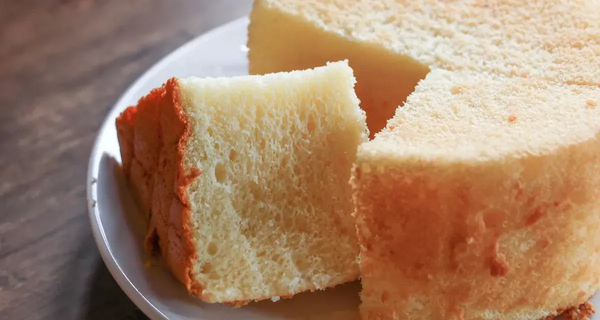 Il segreto per torte alte e soffici: una fetta di torta soffice e dorata su un piatto bianco, pronta per essere gustata.