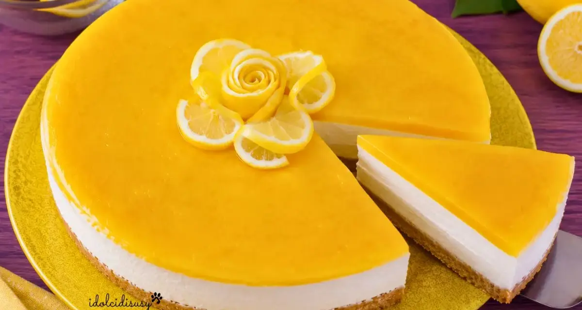 Cheesecake al limone con decorazione di fettine e rosa di limone. Una fetta è già servita.