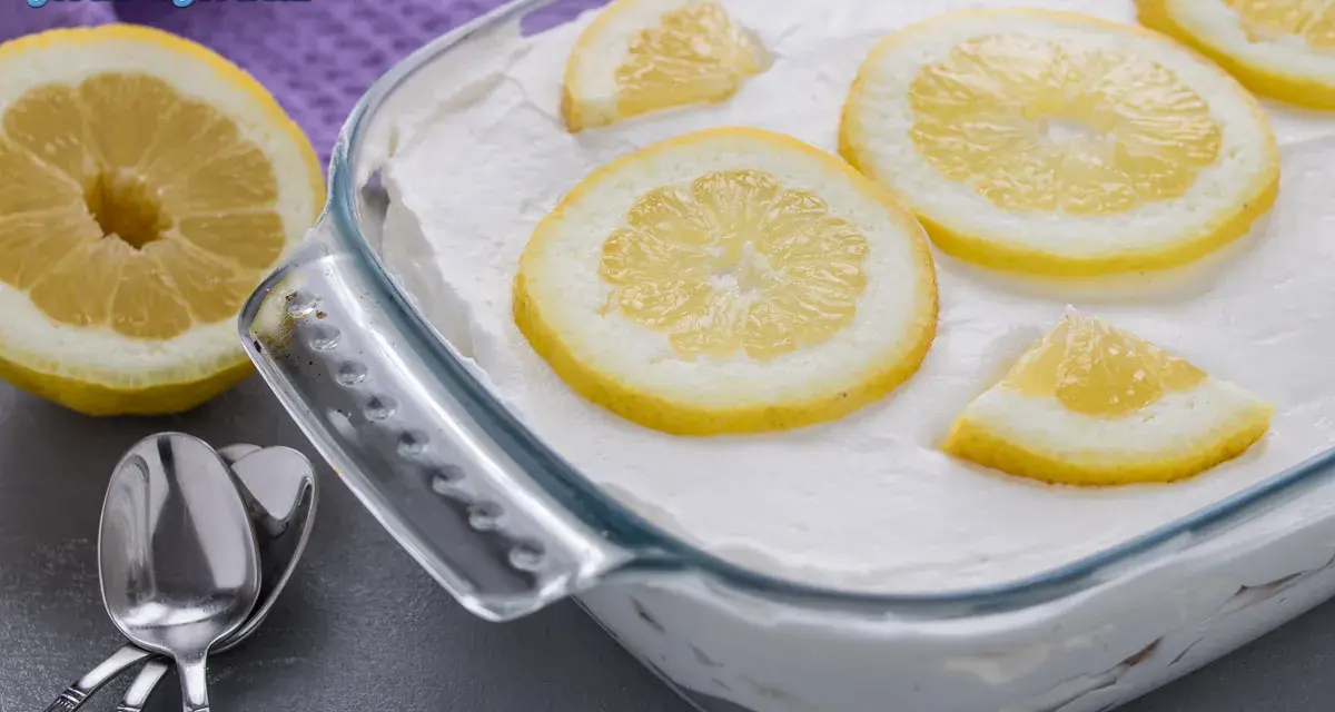 Un delizioso tiramisù al limone, guarnito con fette di limone fresco, pronto per essere gustato.