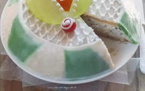 Una fetta di cassata siciliana palermitana, con decorazioni in glassa bianca e canditi colorati, mostra il suo ripieno cremoso.