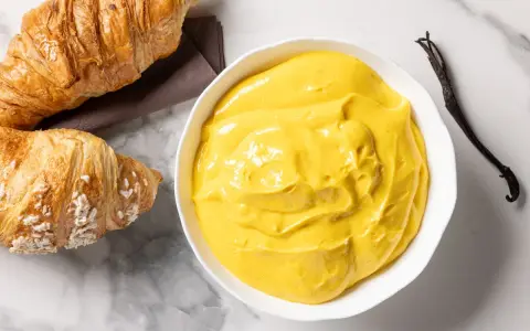 Crema pasticcera senza glutine, vellutata e profumata alla vaniglia, pronta per farcire dolci o da gustare con croissant.