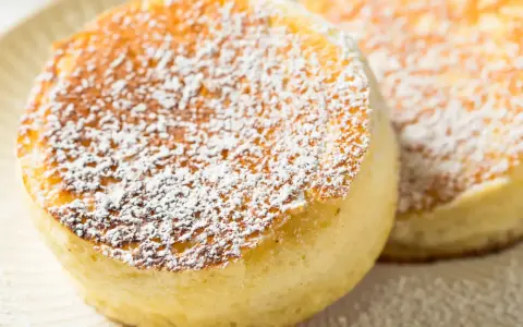 Delicati pancake giapponesi soffici e dorati, spolverati con zucchero a velo.