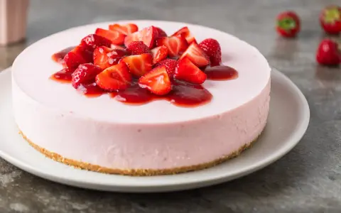 Deliziosa torta fragole e mascarpone senza cottura, guarnita con fragole fresche e salsa rossa.