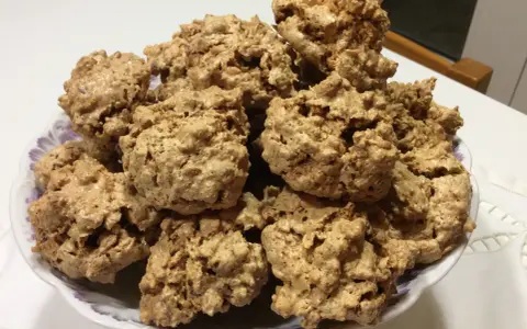 Un piatto pieno di biscotti "brutti ma buoni", croccanti e dorati, perfetti per una pausa golosa.