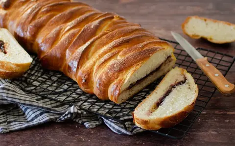 Una deliziosa treccia mochena, dorata e ripiena di marmellata, pronta per essere gustata.