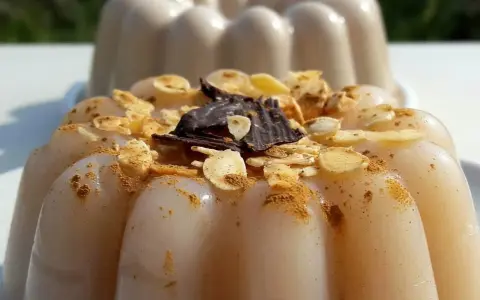 Delizioso biancomangiare ricetta originale siciliana, guarnito con mandorle tostate, cannella e scaglie di cioccolato fondente.