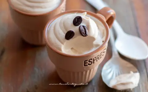 Deliziosa crema caffè fredda in tazzine, guarnita con chicchi di caffè. Perfetta per una pausa rinfrescante.
