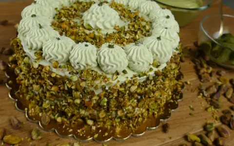 Delizioso dolce con crema al pistacchio già pronta, ricoperto di granella di pistacchi e decorato con ciuffi di crema.