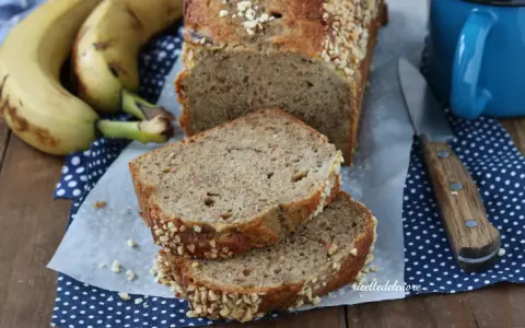Fetta di banana bread senza burro, soffice e profumato, con croccante copertura di frutta secca. Perfetto per la colazione.