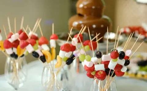 Spiedini di frutta e marshmallow pronti per essere intinti nella fontana di cioccolato come funziona.